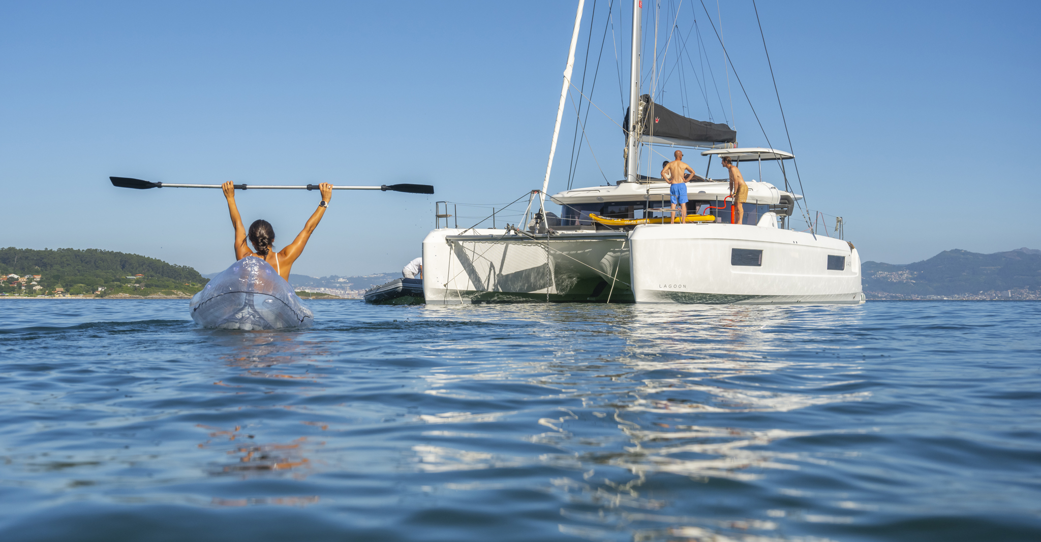 Guests kayaking beside a TMM catamaran during a sailing vacation in the British Virgin Islands.
